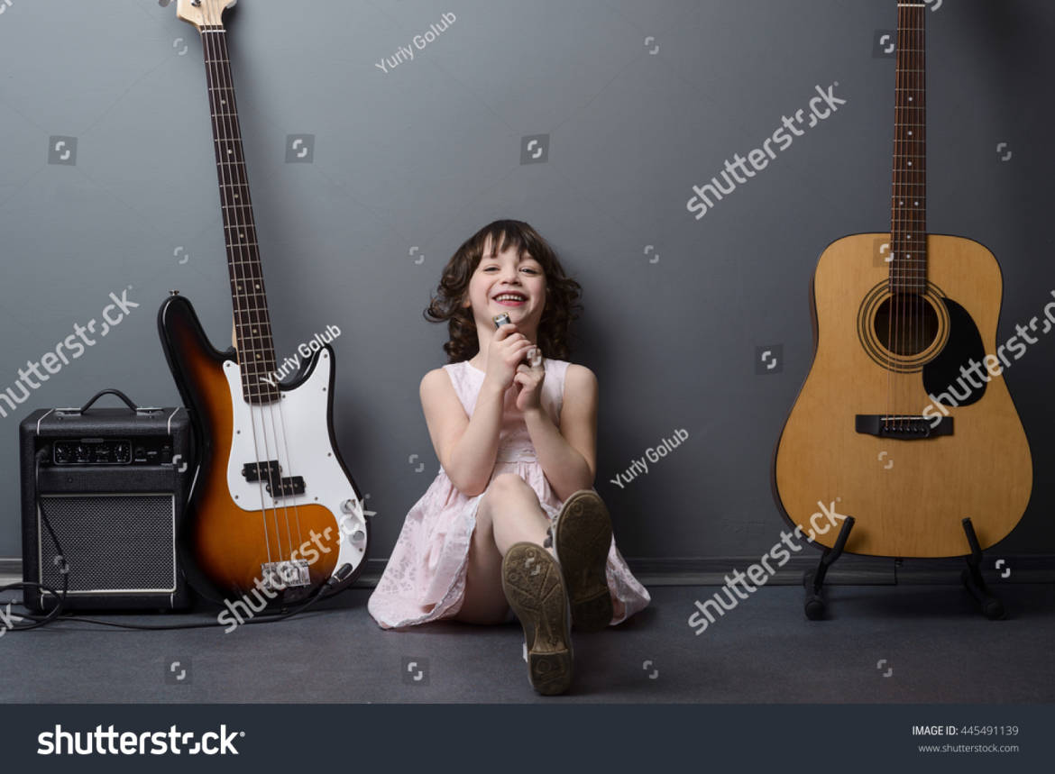 stock-photo-laughing-girl-on-the-floor-in-the-company-of-musical-instruments-harmonica-acoustic-and-bass-445491139.jpg