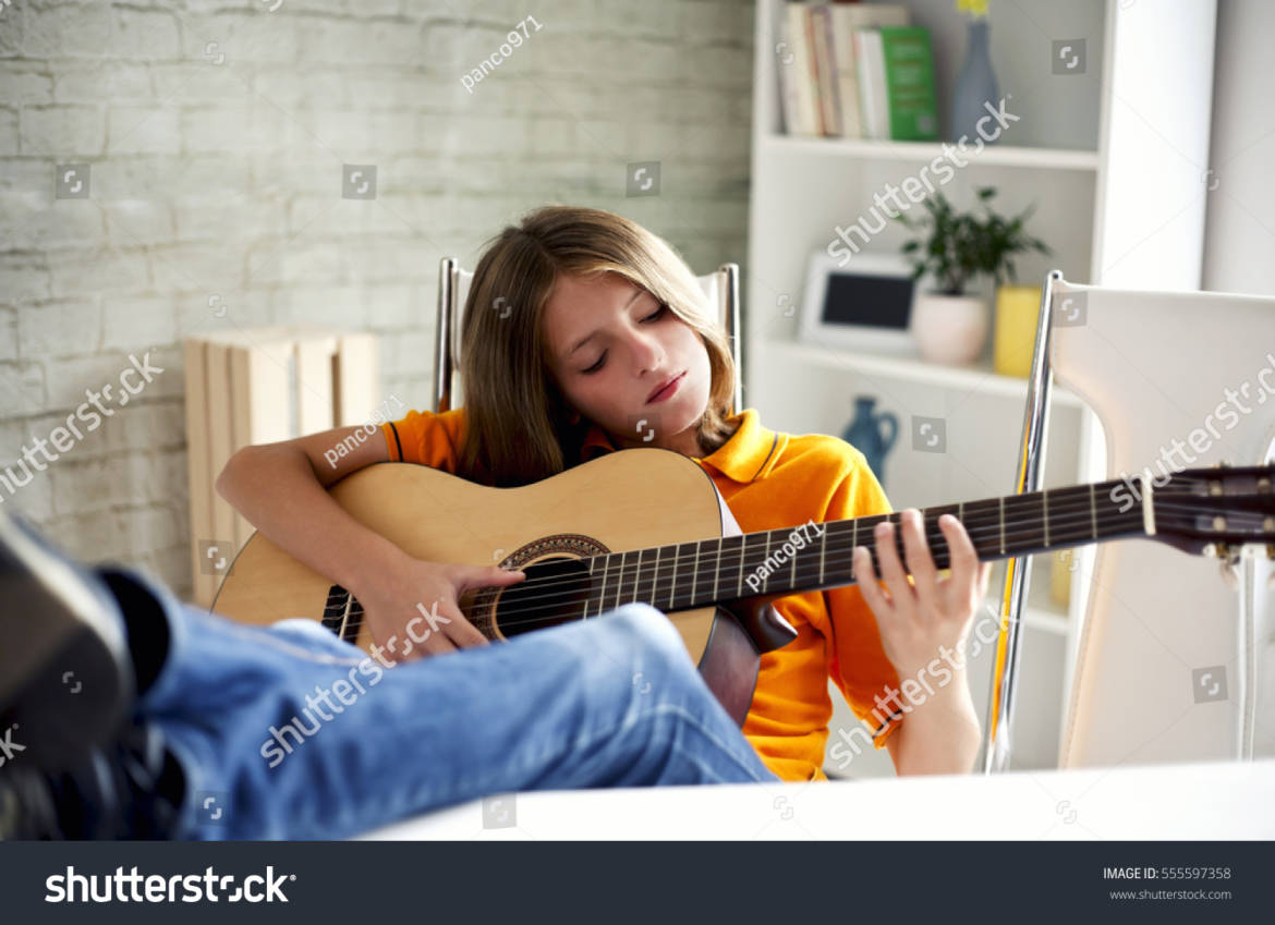 stock-photo-boy-enjoys-playing-the-guitar-555597358.jpg